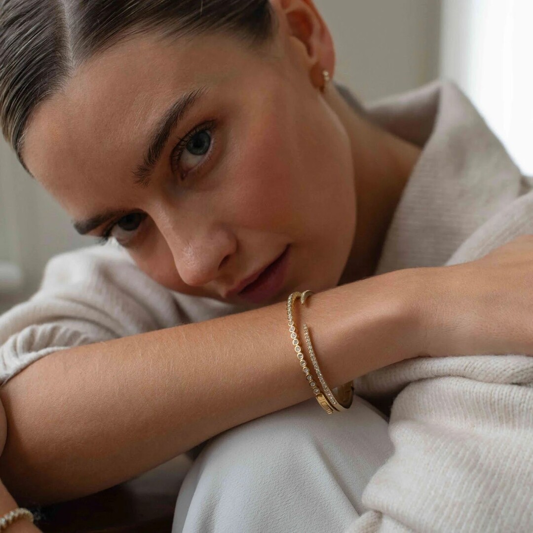 Woman wearing gold bracelets.